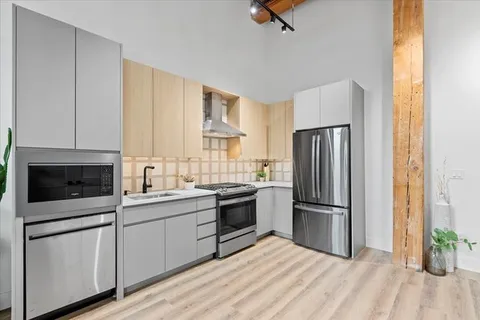 a kitchen with a sink stainless steel appliances and white cabinets