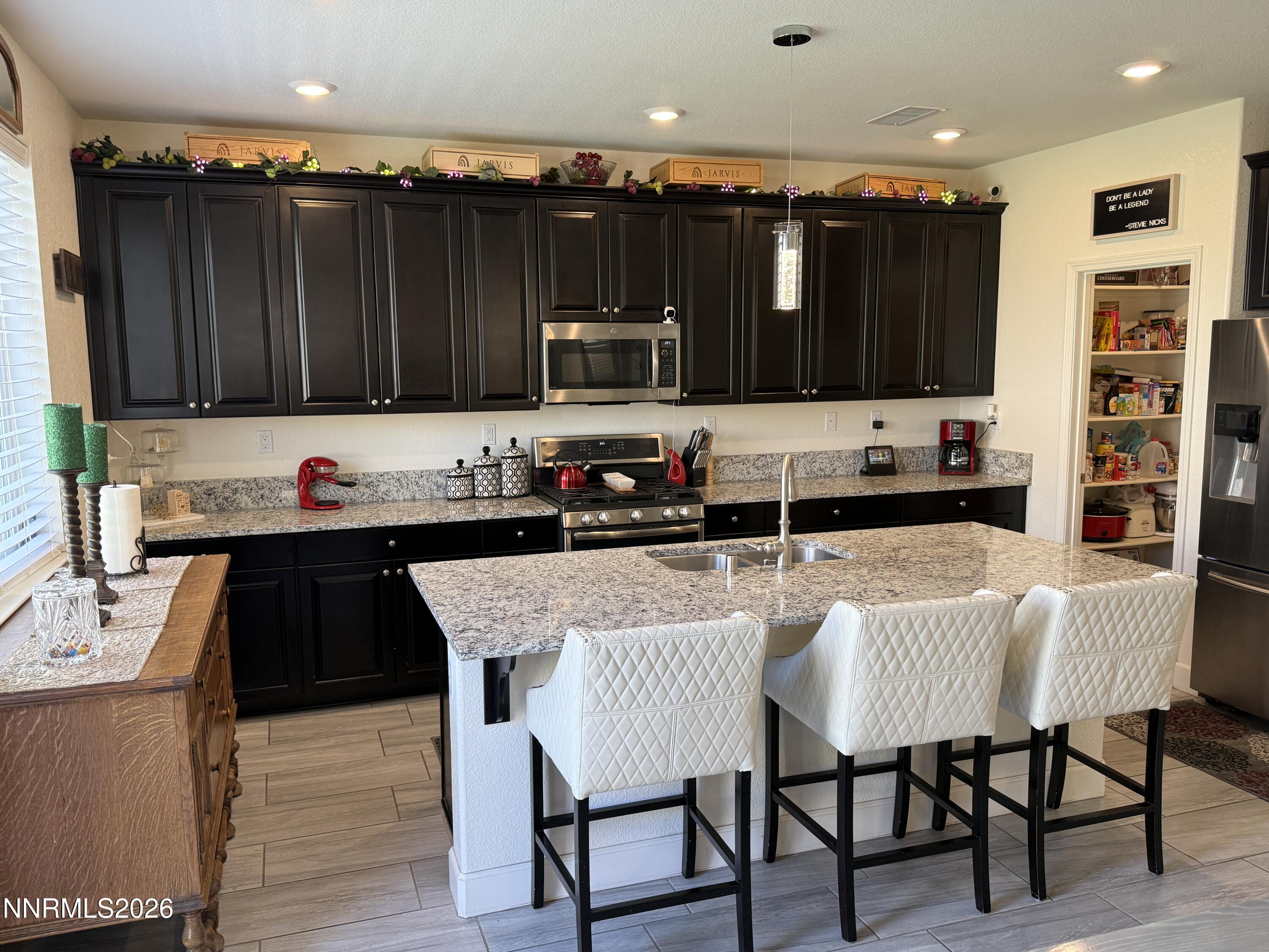 9766 Pachuca Drive Reno, NV 89521 - Photo 9 of 59 a kitchen with granite countertop a stove and a refrigerator