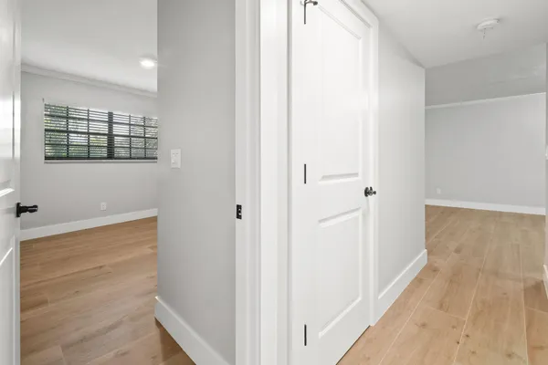 a view of a hallway with wooden floor and staircase