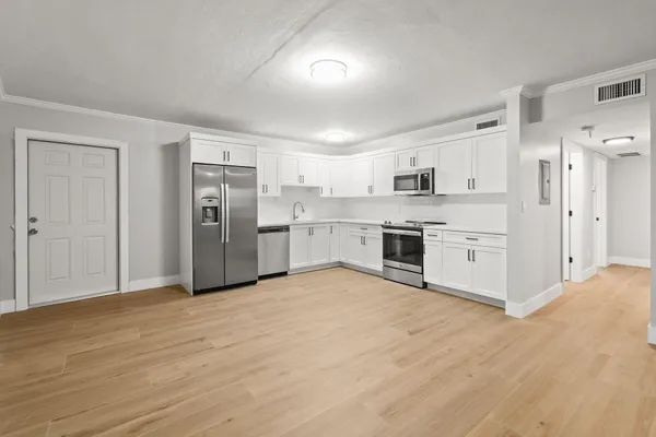 a view of a kitchen with a sink and a refrigerator