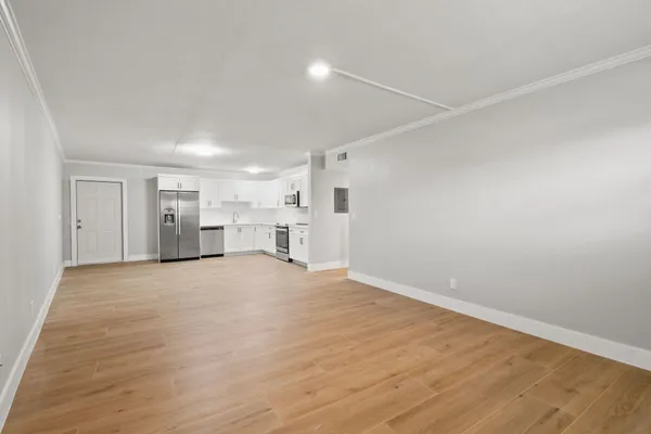 a view of empty room with wooden floor