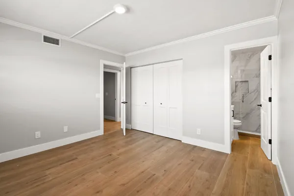 a view of an empty room with wooden floor