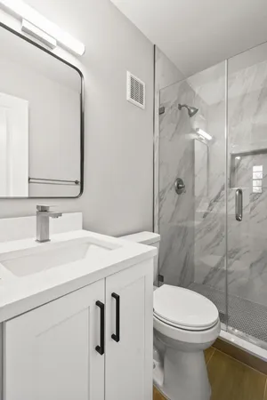 a bathroom with a sink a toilet and shower