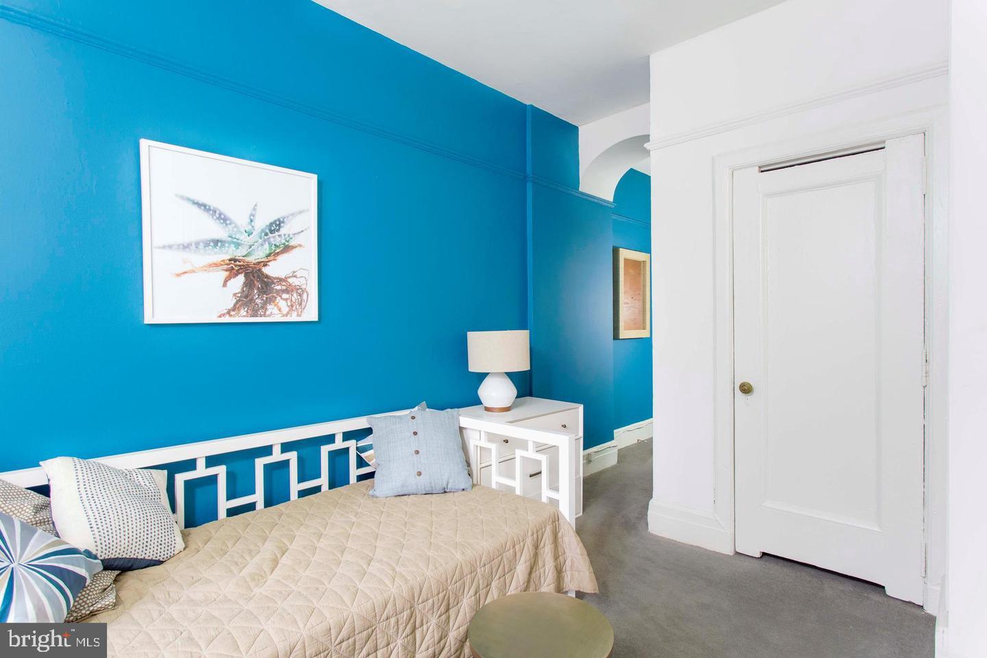 1229 Chestnut Street, Unit 706 Philadelphia, PA 19107 - Photo 16 of 21 a bedroom with a bed and a lamp on dresser