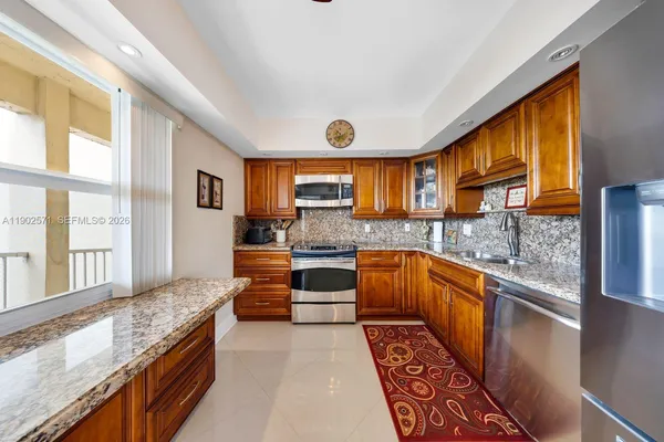 a large kitchen with stainless steel appliances granite countertop a stove a sink and a granite counter tops