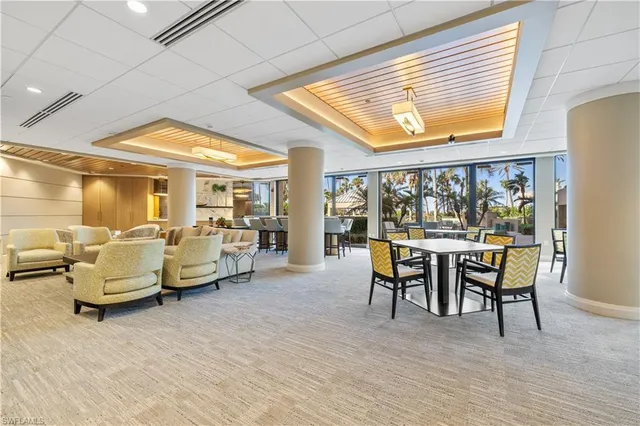 a dining room with furniture and a large window