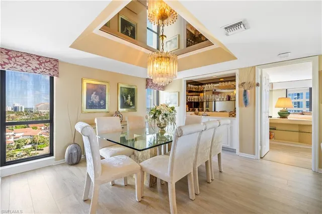a dining room with furniture a chandelier and wooden floor