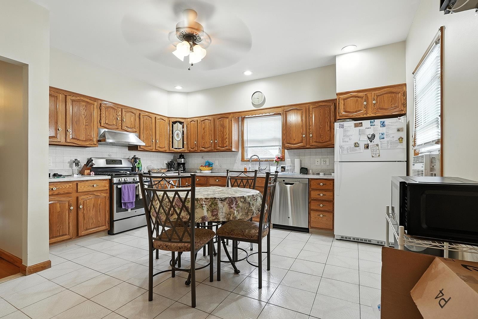 961 Avenue C Bayonne, NJ 07002 - Photo 12 of 21 a kitchen with a refrigerator a stove top oven a sink dishwasher and white cabinets with wooden floor