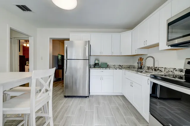 a kitchen with stainless steel appliances granite countertop a refrigerator sink and stove