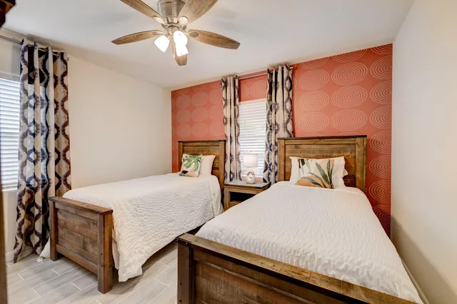a bedroom with two beds and a chandelier
