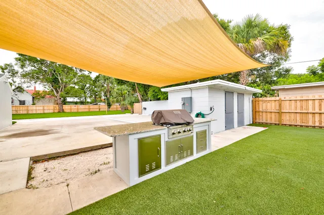 a view of a backyard with lawn chairs microwave and stove