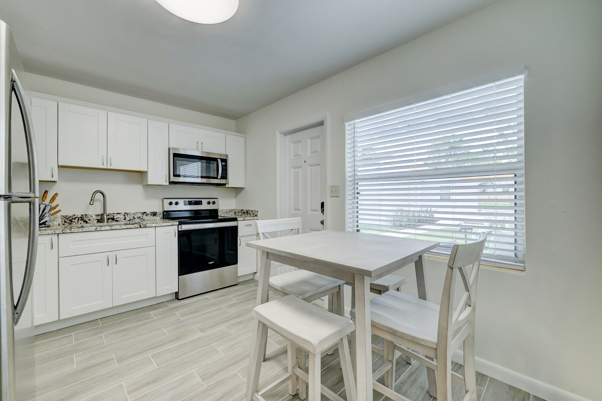 125 South 10th Street Fort Pierce, FL 34950 - Photo 9 of 30 a kitchen with a table chairs microwave and cabinets