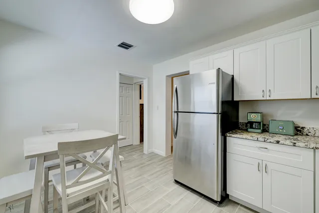 a refrigerator freezer sitting in a kitchen with white cabinets