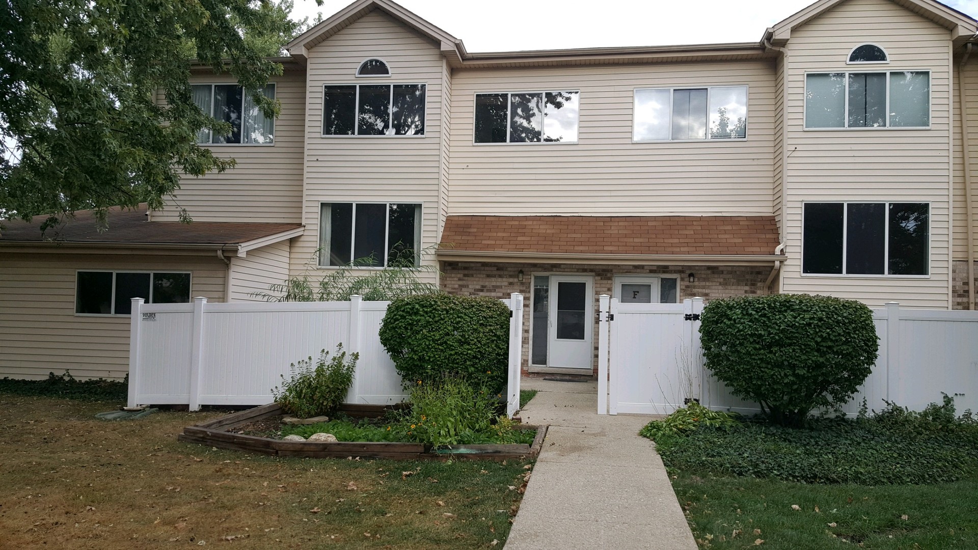 332 Park Ridge Lane, Unit E Aurora, IL 60504 - Photo 1 of 21 a front view of a house with a yard and garage