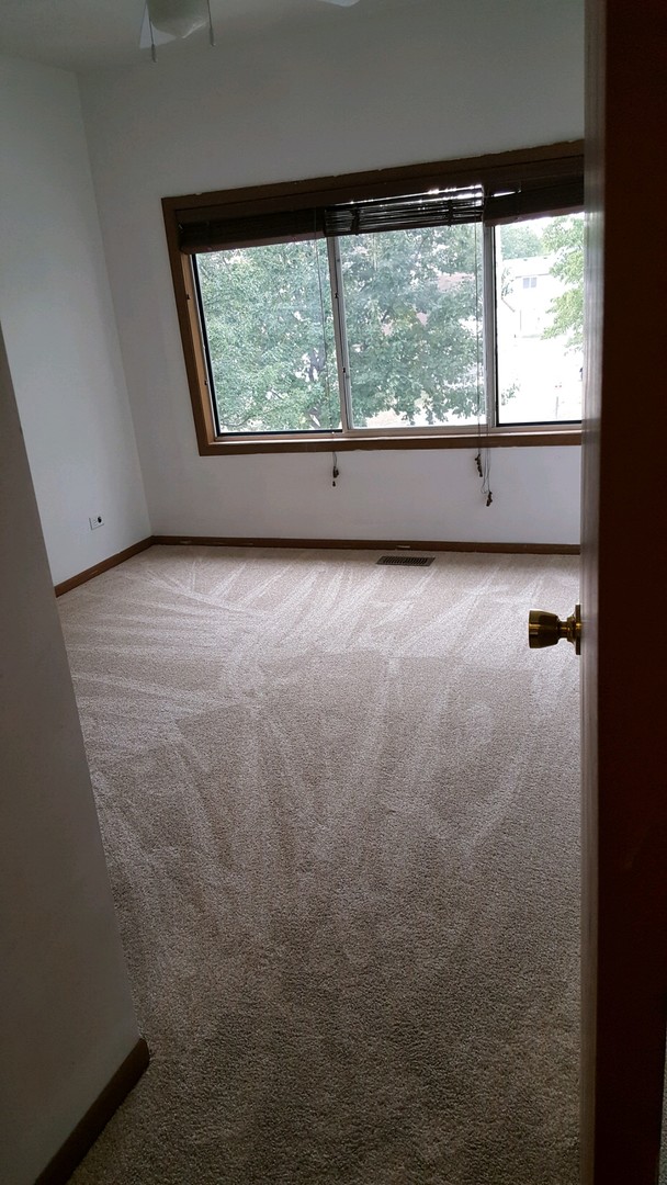 332 Park Ridge Lane, Unit E Aurora, IL 60504 - Photo 15 of 21 an empty room with a large window