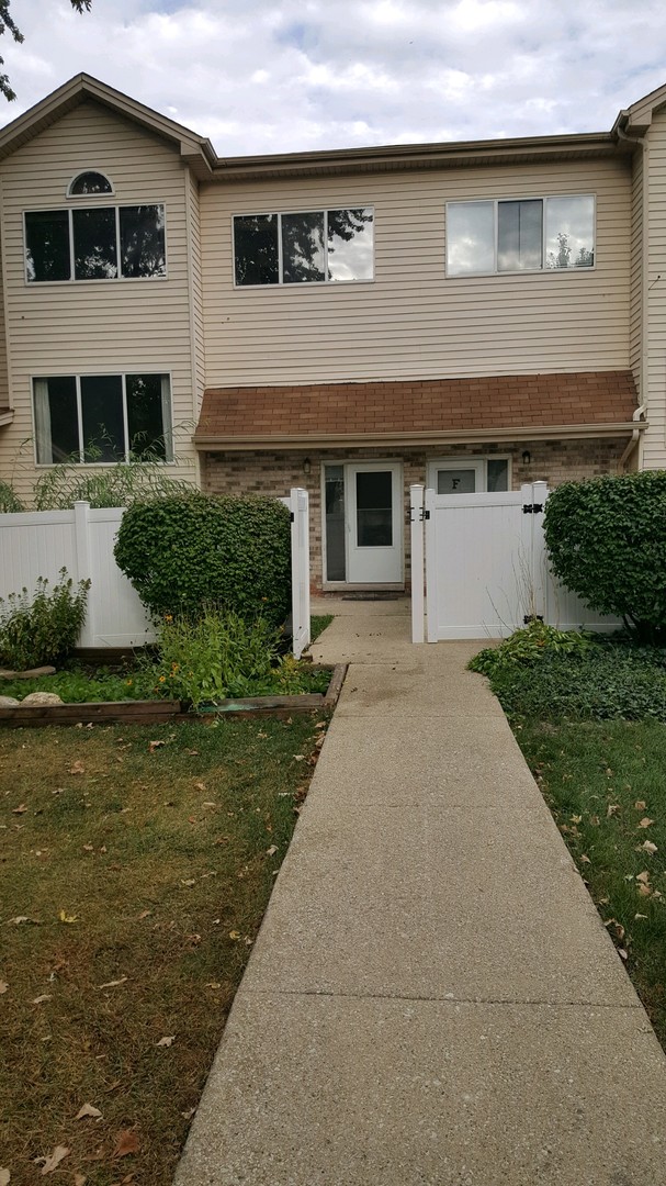 332 Park Ridge Lane, Unit E Aurora, IL 60504 - Photo 2 of 21 a front view of a house with a yard and garage