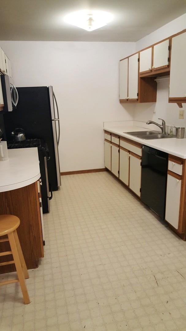 332 Park Ridge Lane, Unit E Aurora, IL 60504 - Photo 6 of 21 a kitchen with a sink a stove and cabinets