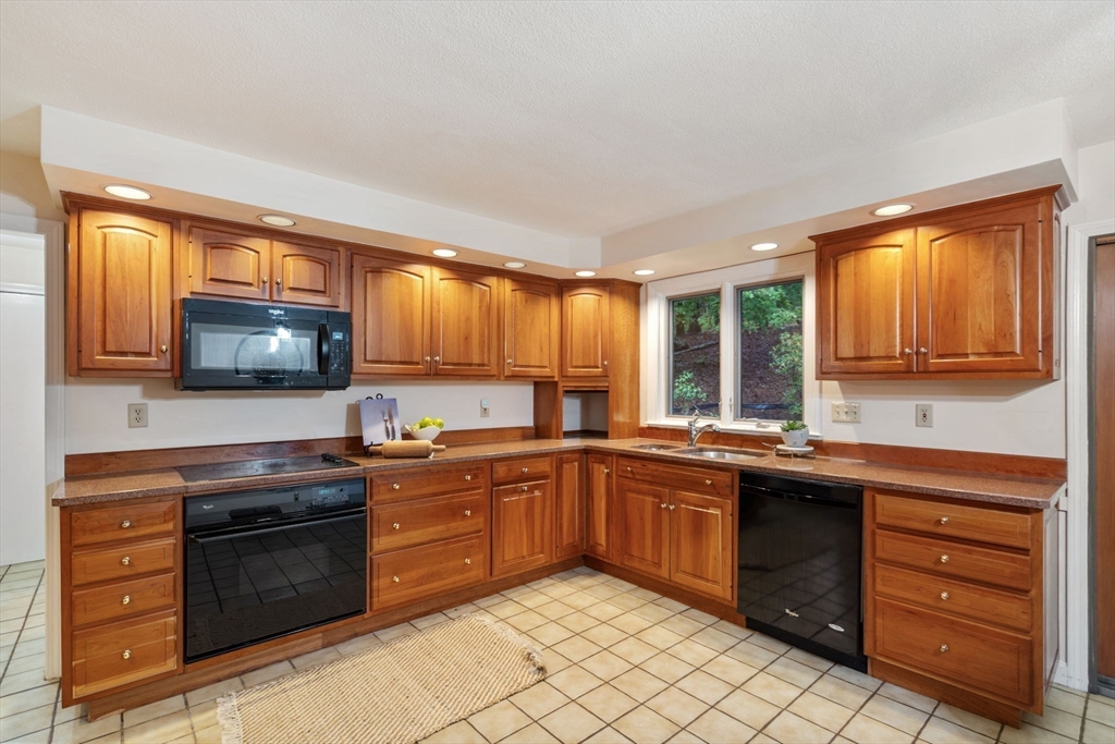 369 Border Road Concord, MA 01742 - Photo 13 of 34 a kitchen with stainless steel appliances granite countertop a stove sink and cabinets