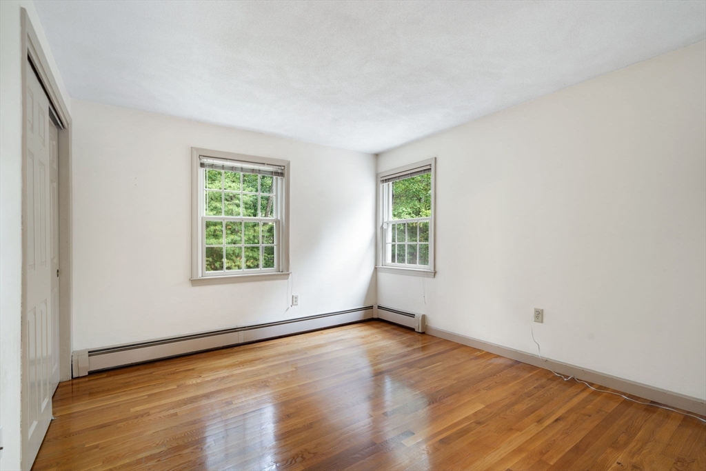 369 Border Road Concord, MA 01742 - Photo 24 of 34 an empty room with wooden floor and windows