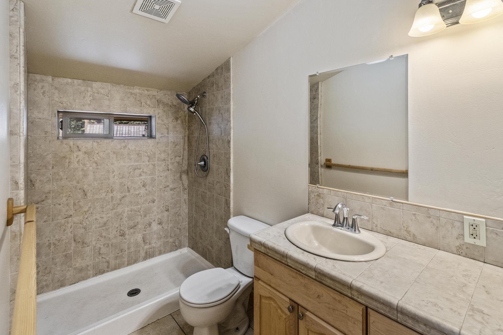 6980 Toyon Road Tahoe Vista, CA 96148 - Photo 14 of 20 a bathroom with a granite countertop sink toilet and shower