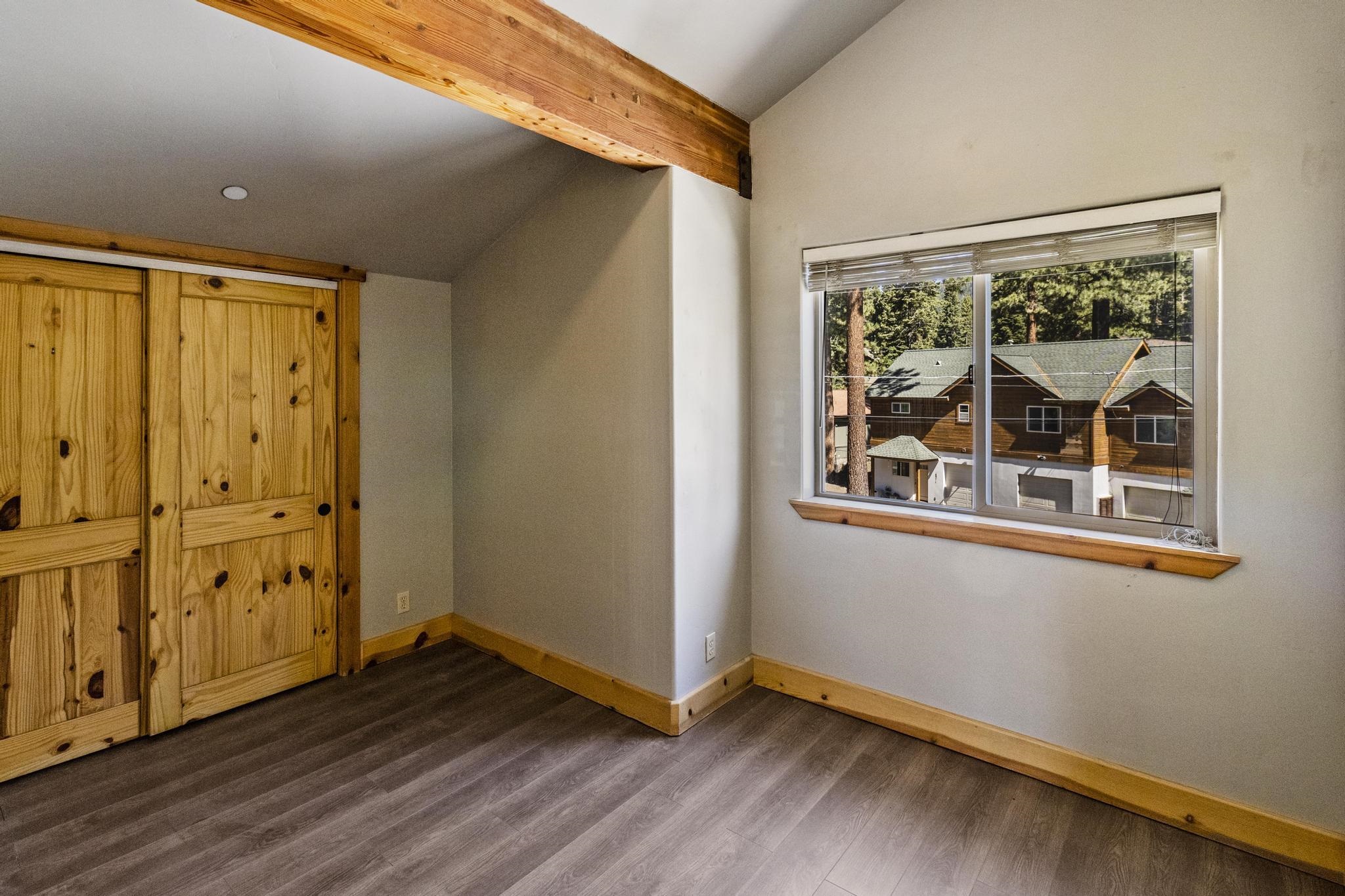 6980 Toyon Road Tahoe Vista, CA 96148 - Photo 16 of 20 an empty room with wooden floor and windows
