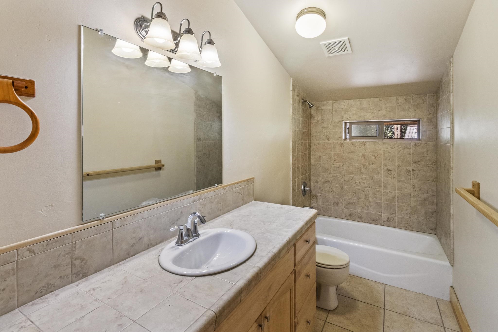6980 Toyon Road Tahoe Vista, CA 96148 - Photo 17 of 20 a bathroom with a granite countertop sink and a mirror