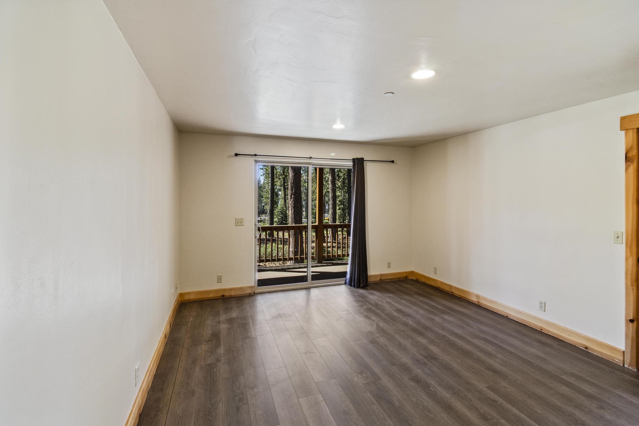 6980 Toyon Road Tahoe Vista, CA 96148 - Photo 6 of 20 an empty room with wooden floor and windows