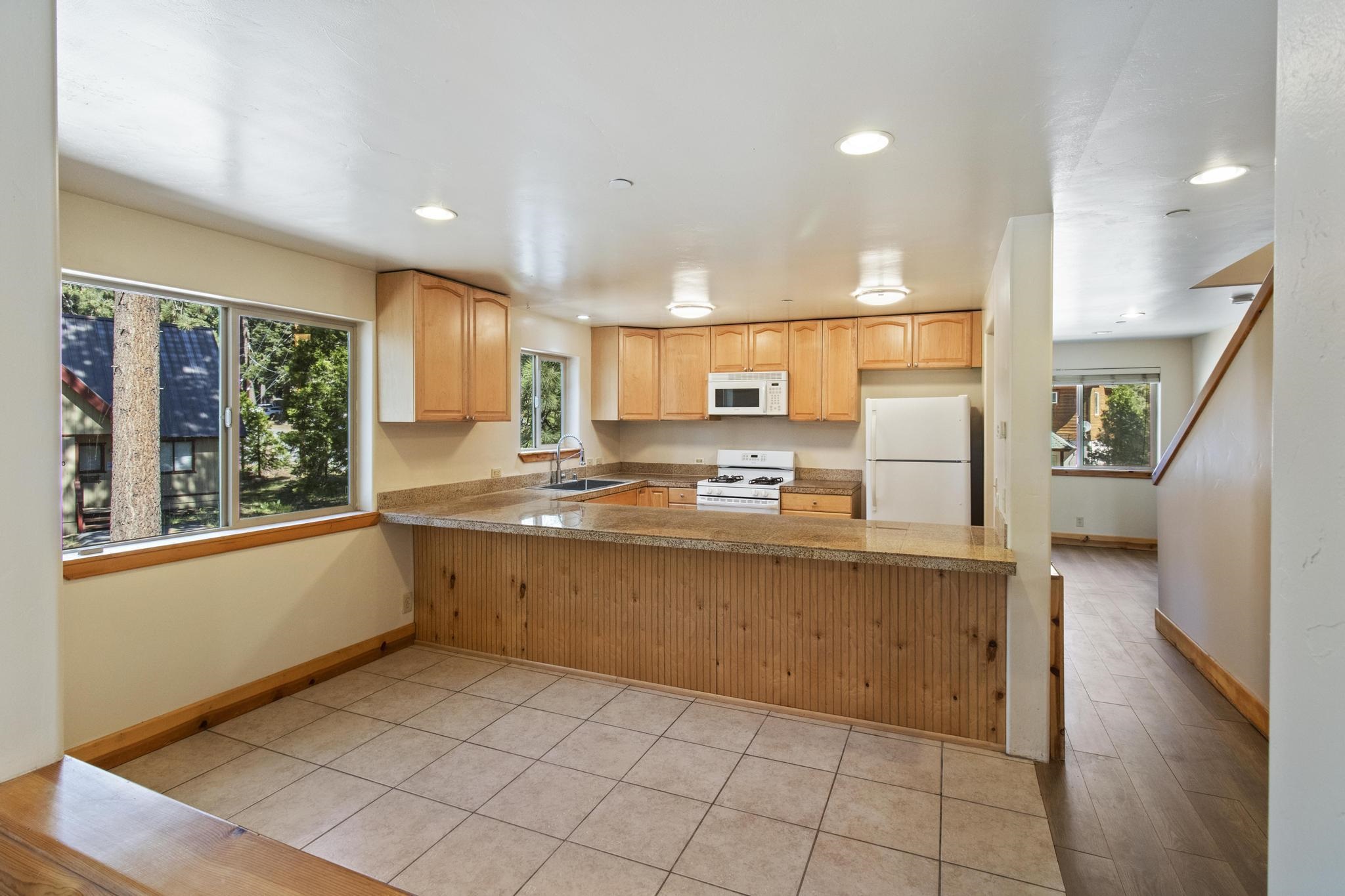 6980 Toyon Road Tahoe Vista, CA 96148 - Photo 8 of 20 a large kitchen with kitchen island granite countertop a large counter top stainless steel appliances a sink and cabinets