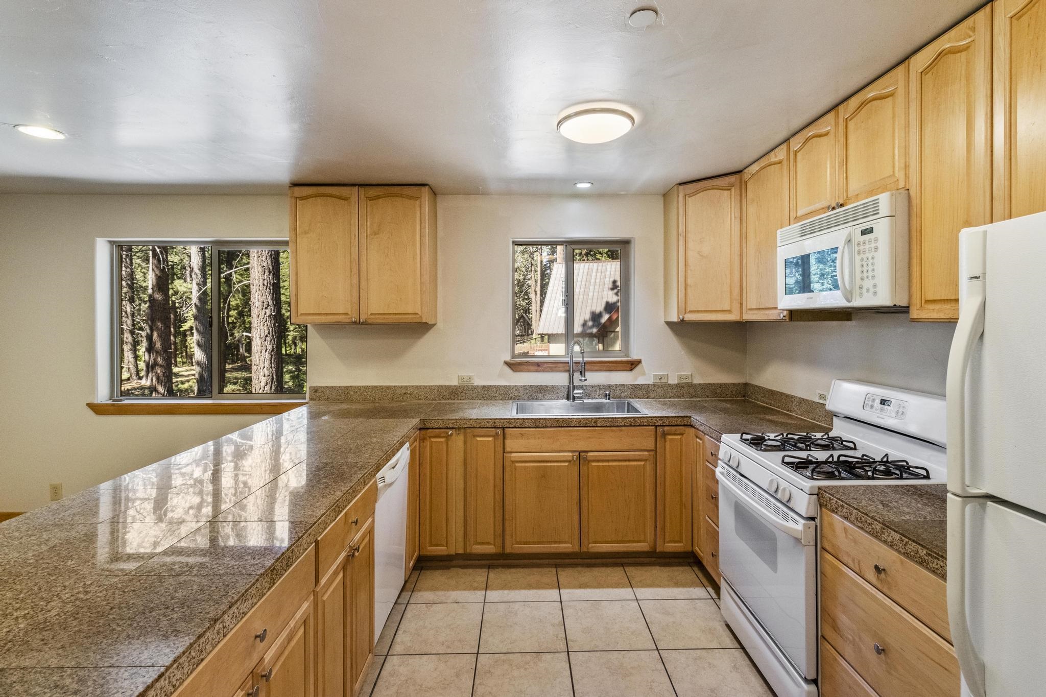 6980 Toyon Road Tahoe Vista, CA 96148 - Photo 9 of 20 a kitchen with stainless steel appliances granite countertop a stove a sink and a microwave