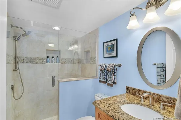 a bathroom with a sink a mirror and a shower