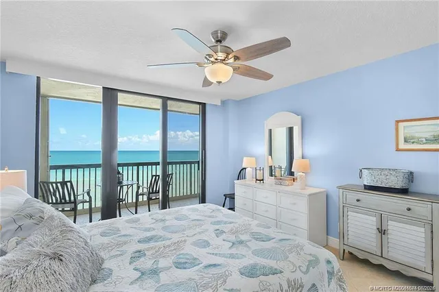 a bedroom with a bed and a large window with the outer view