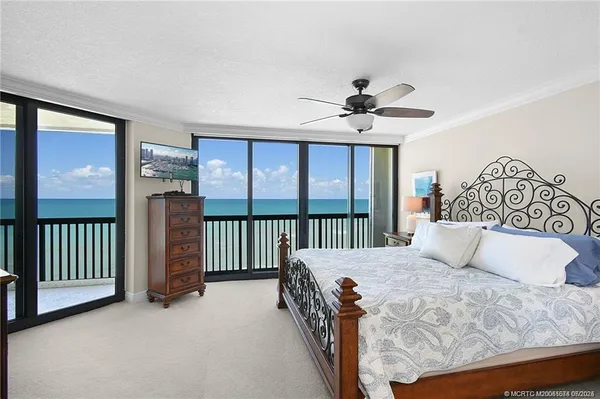 a bedroom with a large bed and a chandelier