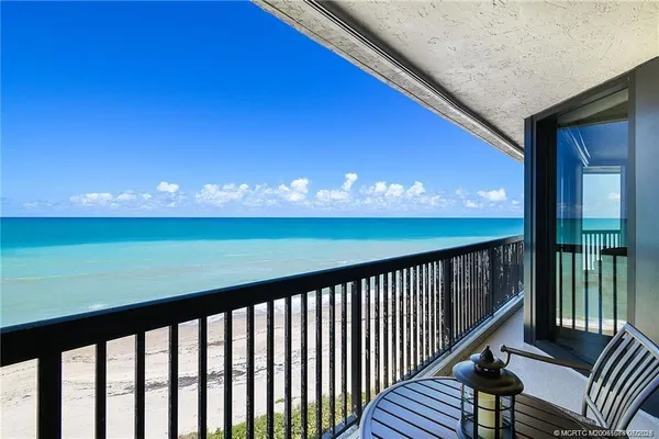 a balcony with wooden floor and outdoor seating