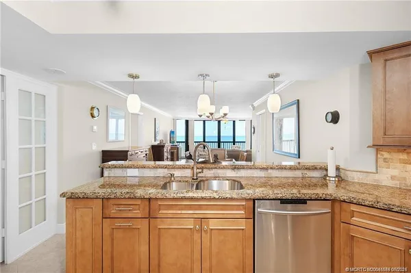 a kitchen with stainless steel appliances granite countertop a sink and a white cabinets