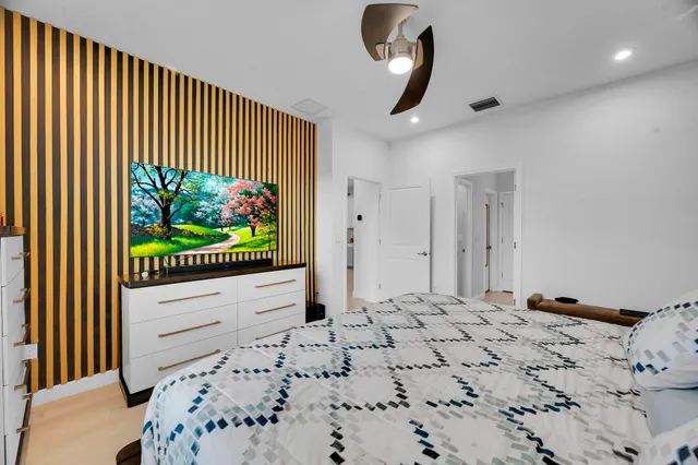 a bedroom with a bed and a flat screen tv