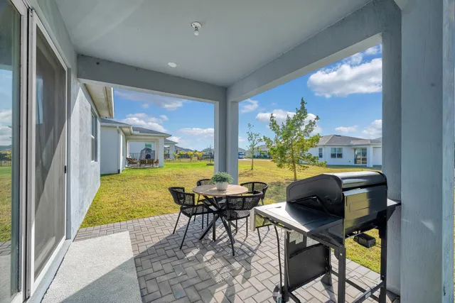 a dining room with furniture and a floor to ceiling window