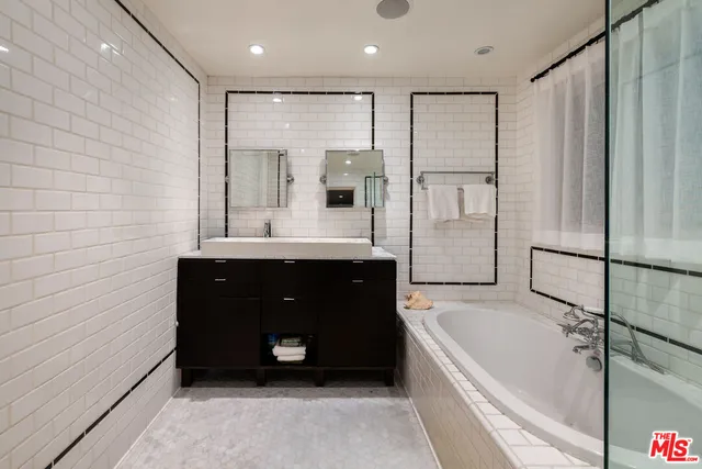 a bathroom with a bathtub shower and a sink
