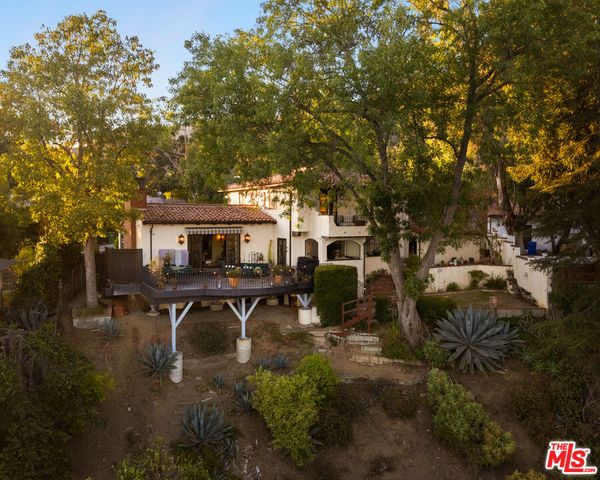 a view of a house with backyard and sitting area