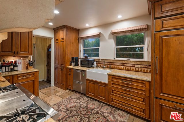 a kitchen with refrigerator cabinets and window