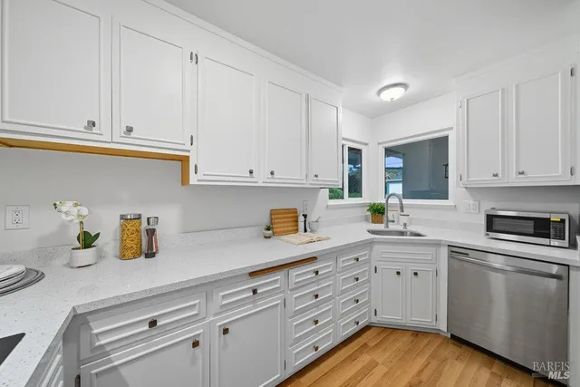 a kitchen with white cabinets and white appliances