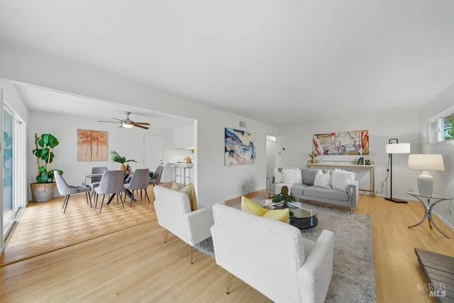 a living room with furniture and a wooden floor