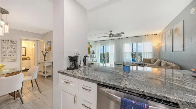 a kitchen with granite countertop a sink and chairs