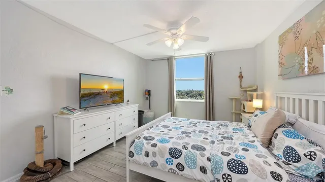 a bedroom with a bed and a flat tv screen on dresser