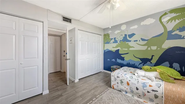 a bedroom with a bed and wooden floor