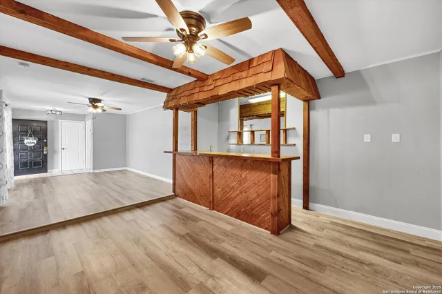 a view of a hallway with wooden floor and a ceiling fan