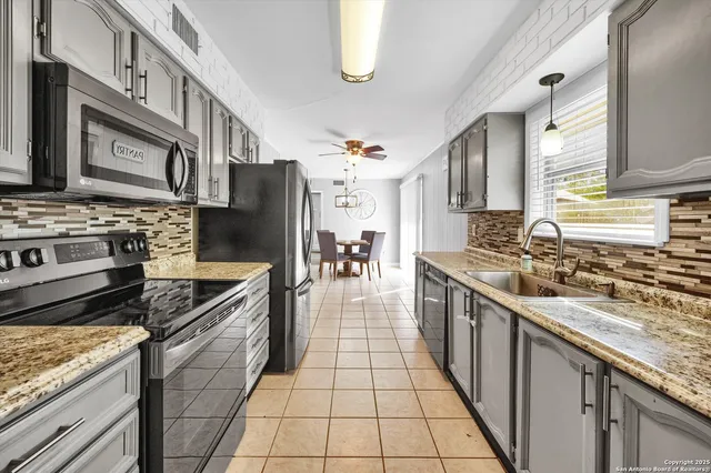 a large kitchen with stainless steel appliances granite countertop a stove a sink dishwasher and oven