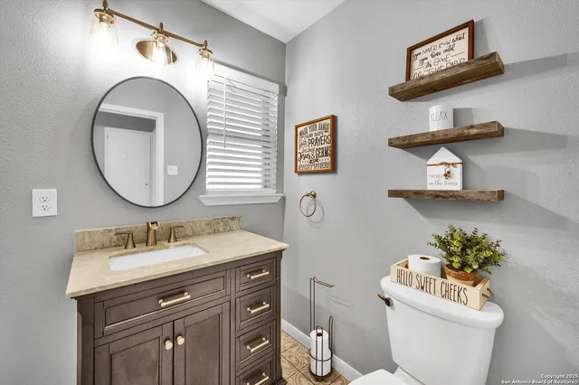 a bathroom with a toilet a sink and a mirror