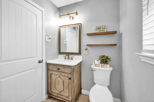 a bathroom with a toilet a sink and mirror