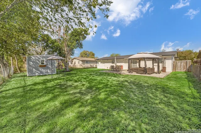 a view of a house with a big yard and large trees
