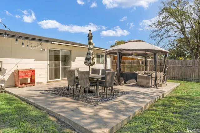 a view of a patio with table and chairs potted plants with wooden floor and fence